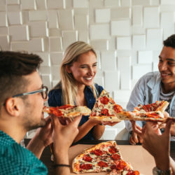 Group of friends enjoying pizza in a restaurant