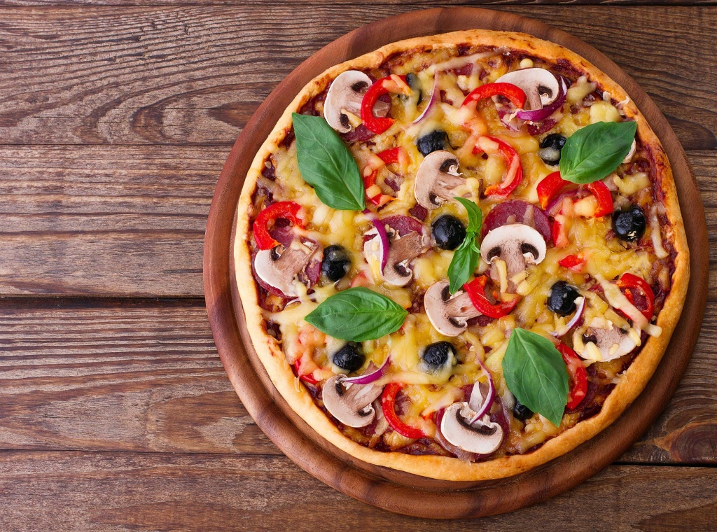 Finished pizza displayed on wooden board